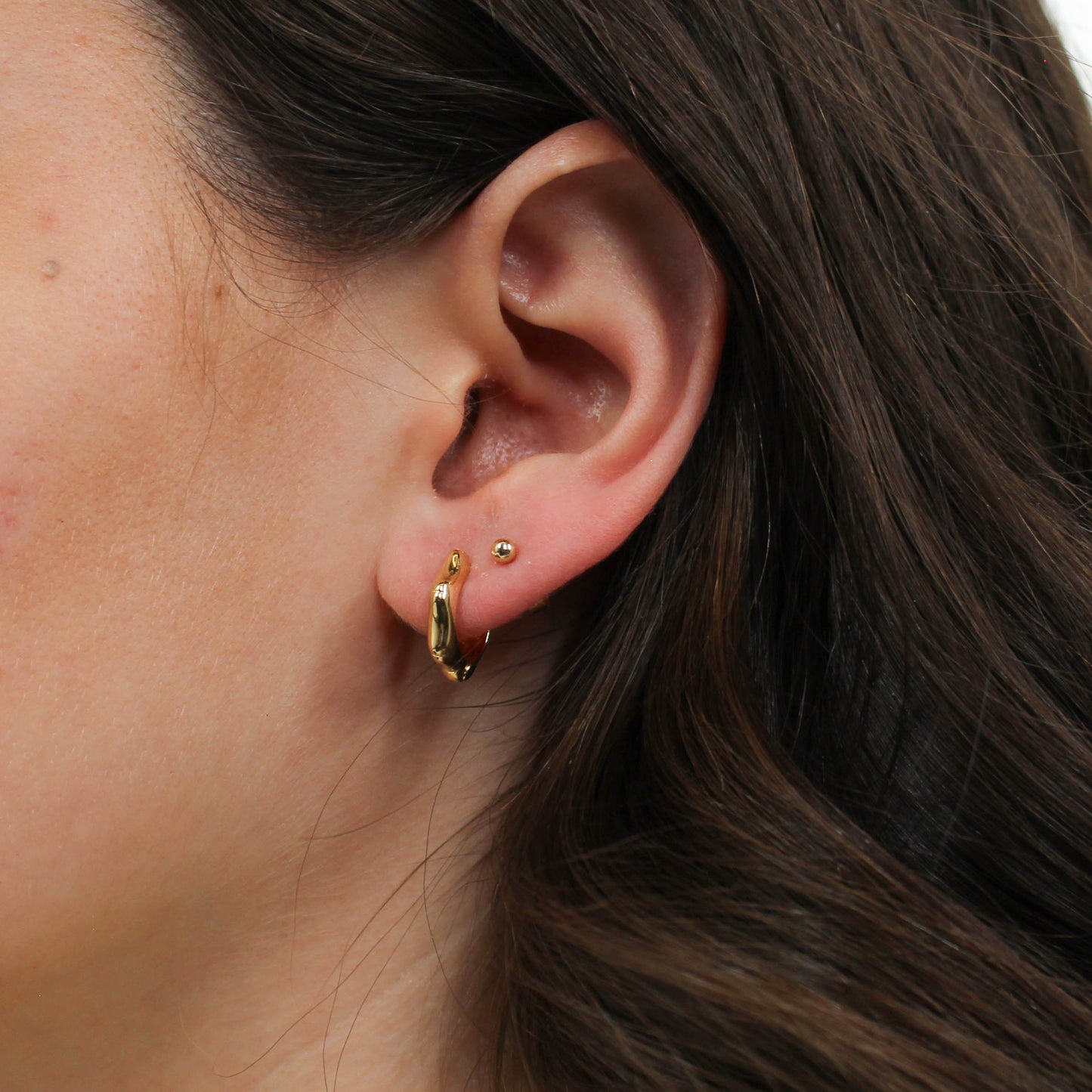 Close-up gold bamboo hoop earrings.