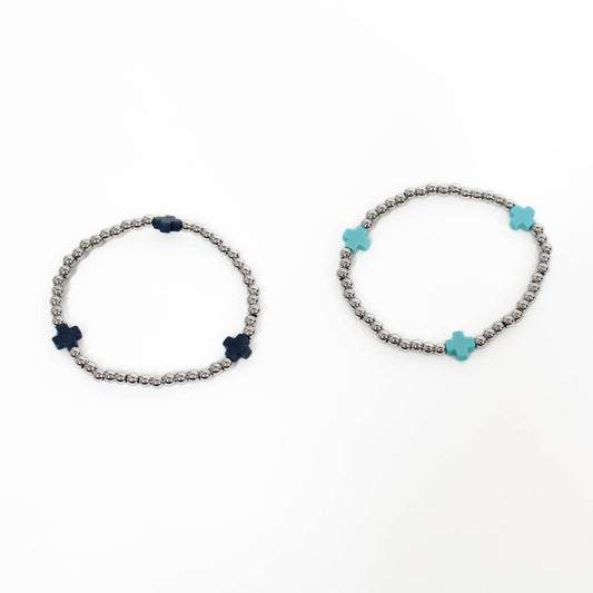 Two bracelets with silver beads and a blue and black cross accents on a white background.