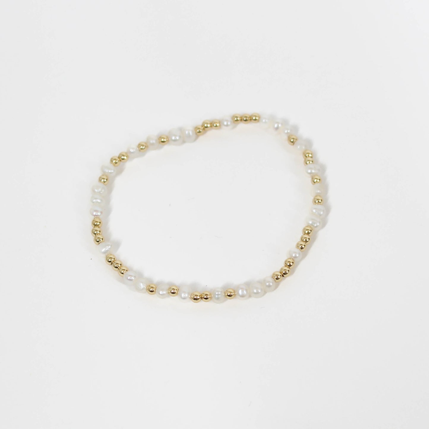 Pearl and gold beaded bracelet on a white background