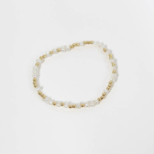 Pearl and gold beaded bracelet on a white background