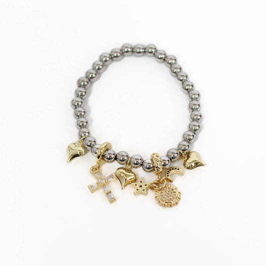 Bracelet with silver beads, gold charms and gold cross on a white background
