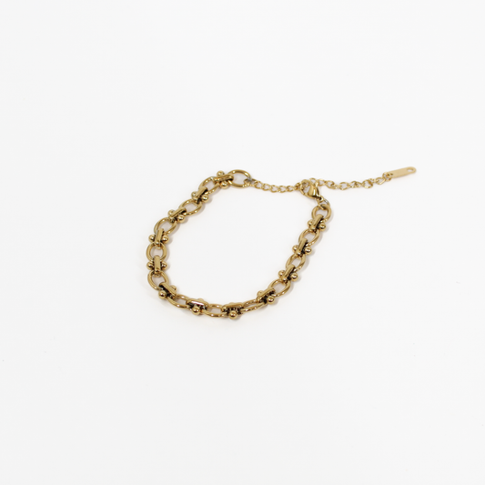 Gold beaded link chain bracelet on a white background