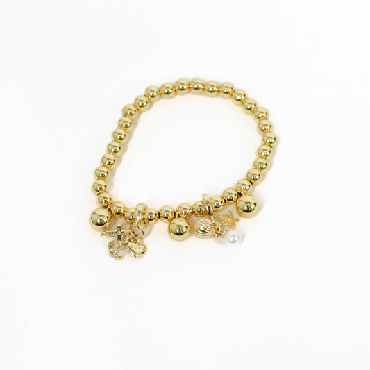 Gold beaded bracelet with nautical charms on a white background