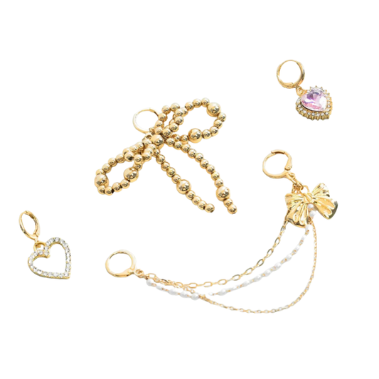 Set of gold bow shoe charms with various designs on a white background