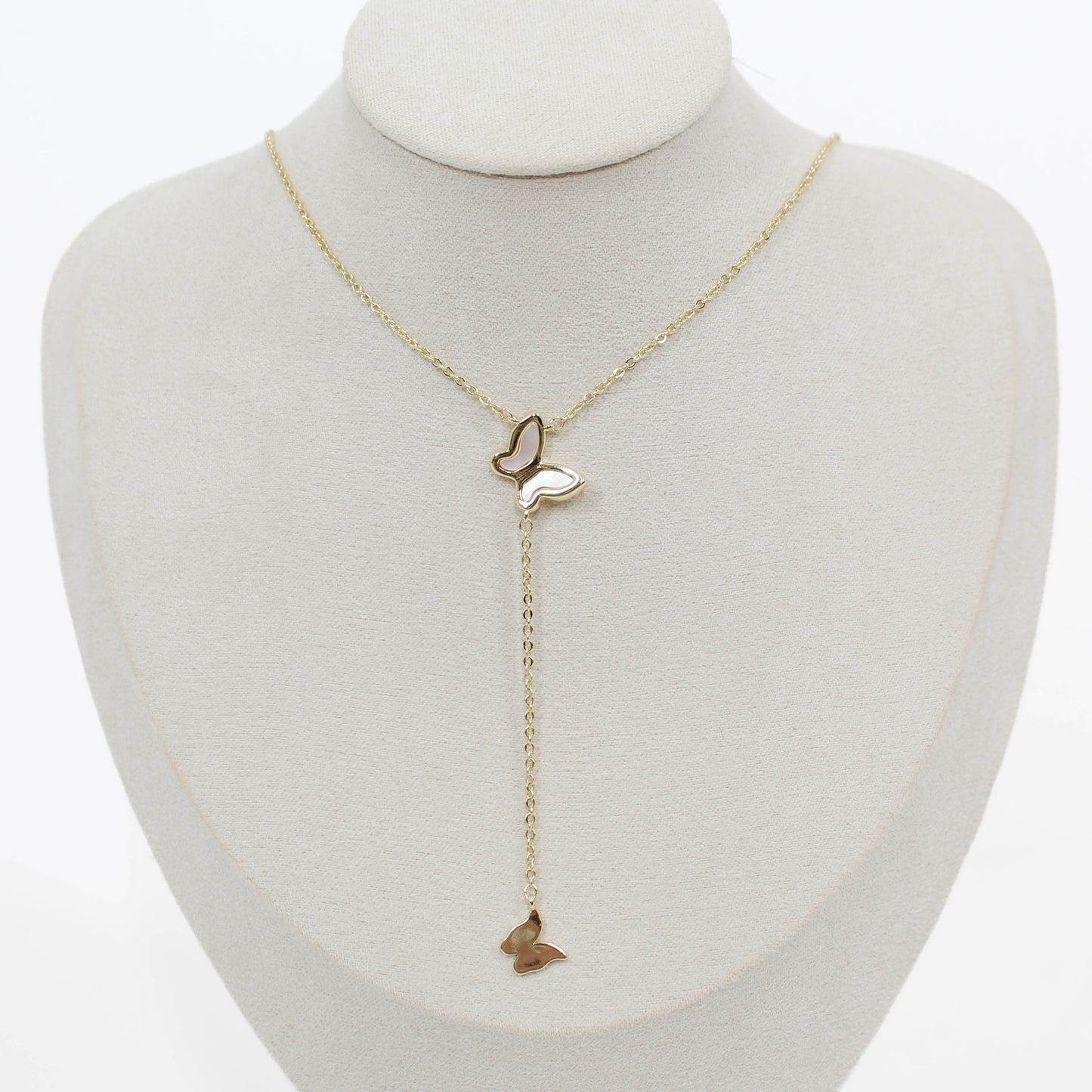 Butterfly lariat necklace on a mannequin with a white background