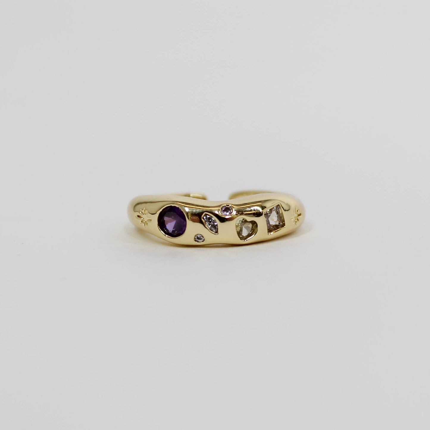 Gold ring with celestial lavender gemstones on a white background