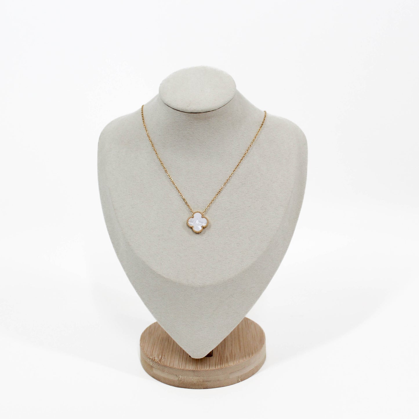 clover pendant Necklace with a white clover pendant on a mannequin bust against a white background