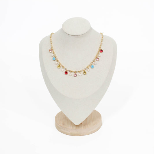 Necklace with colorful beads on a white bust with a wooden base