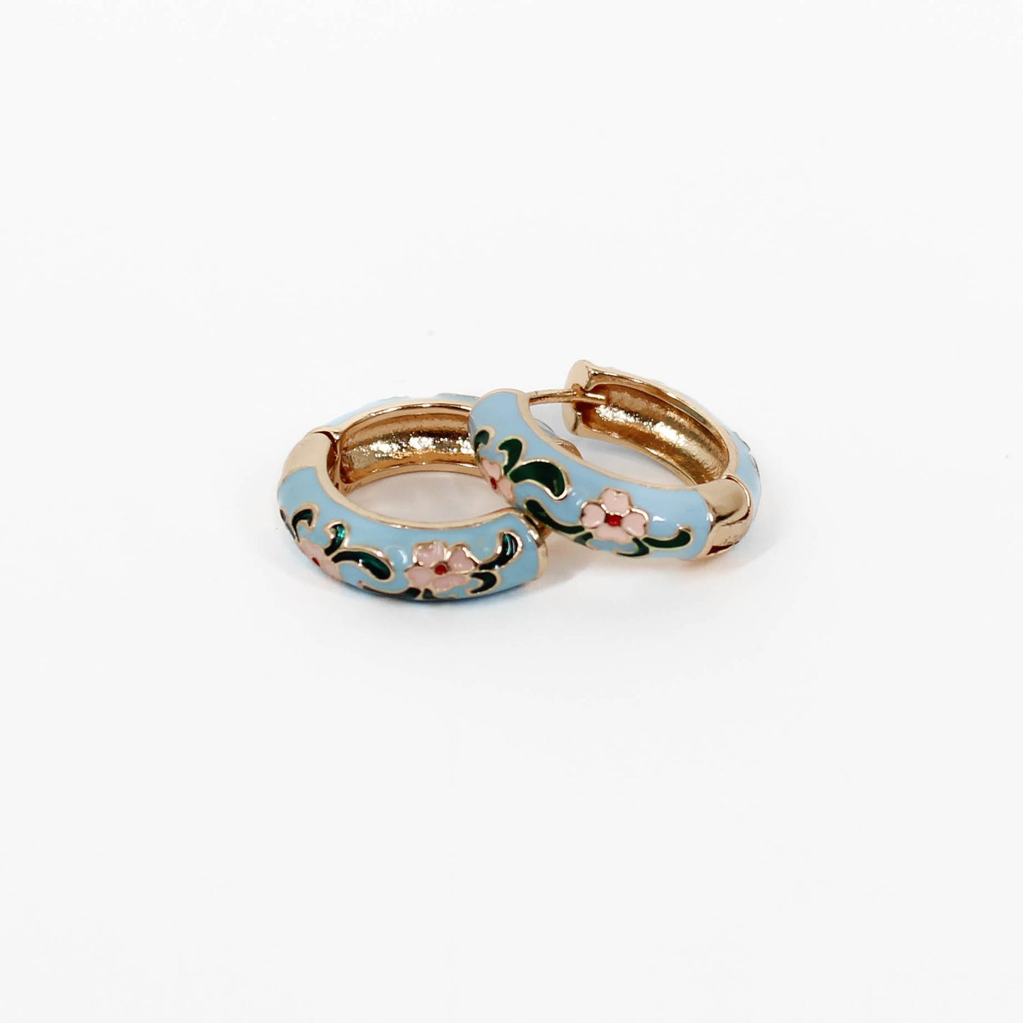 Gold hoop floral huggie earrings with blue and floral designs on a white background