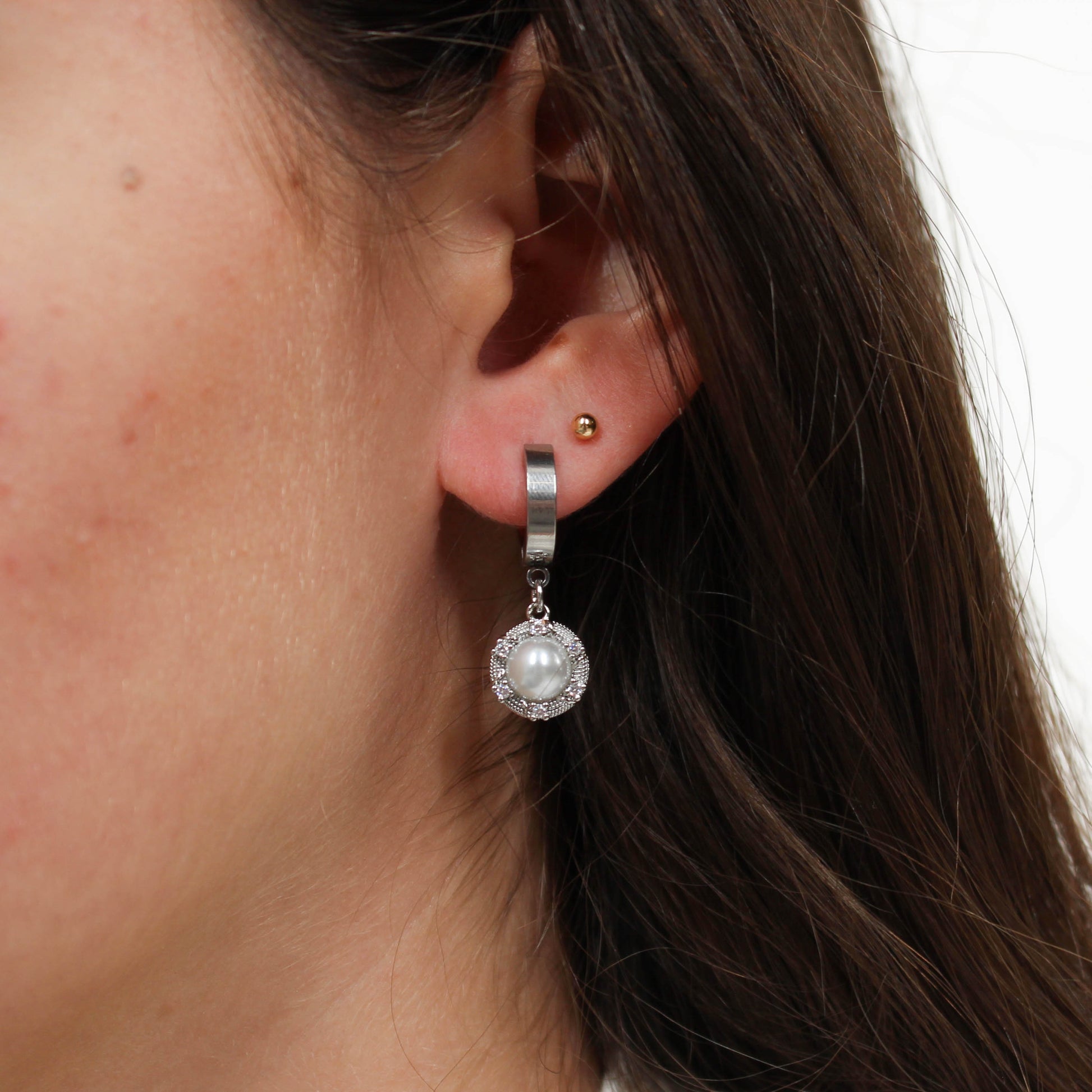 Silver halo pearl drop earring on ear