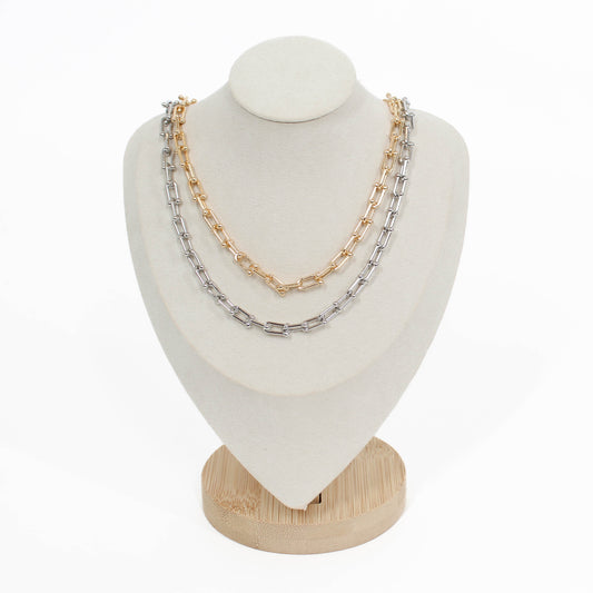 Two chain hardware necklaces stacked on a white mannequin bust with a white background