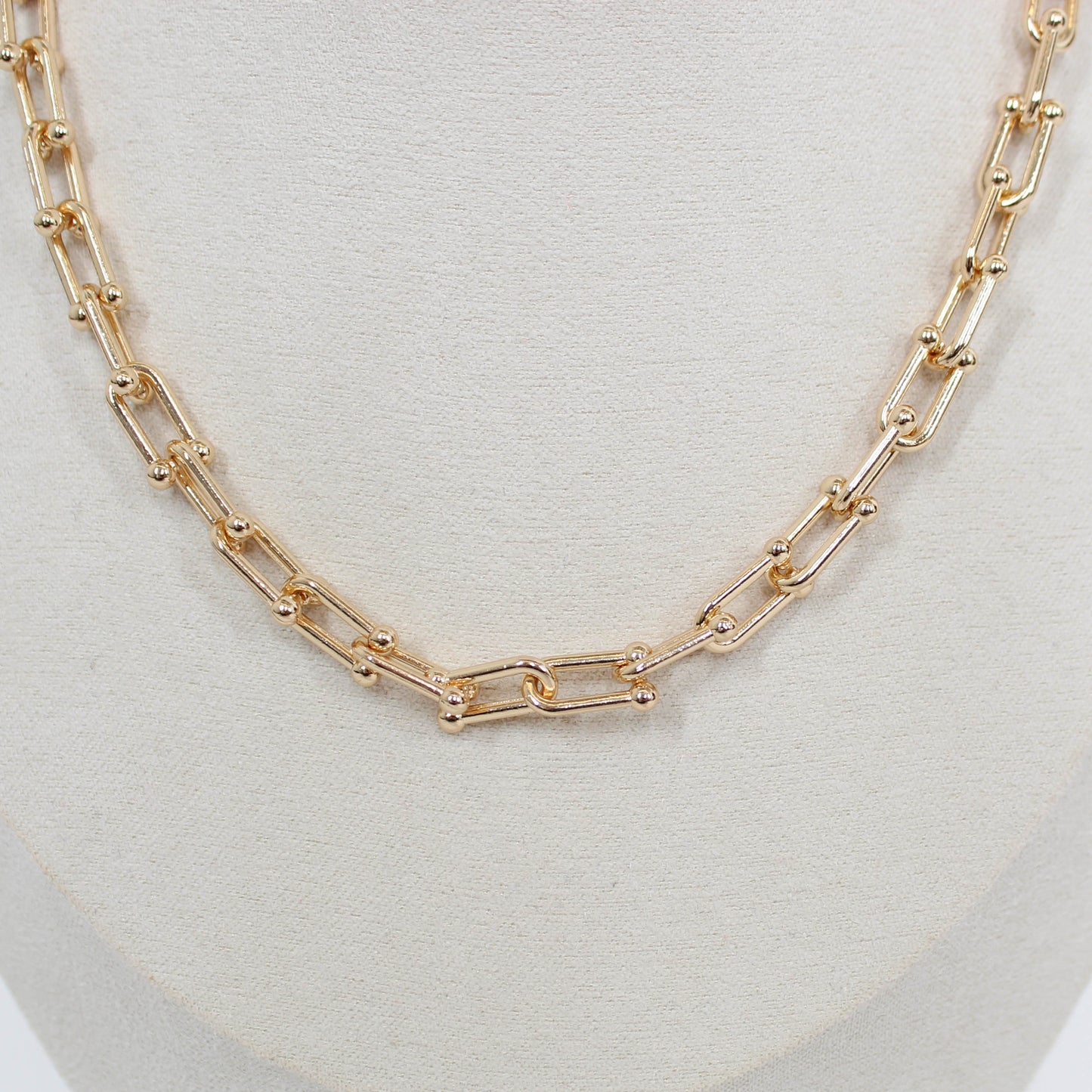 Gold chain hardware necklace on a white background