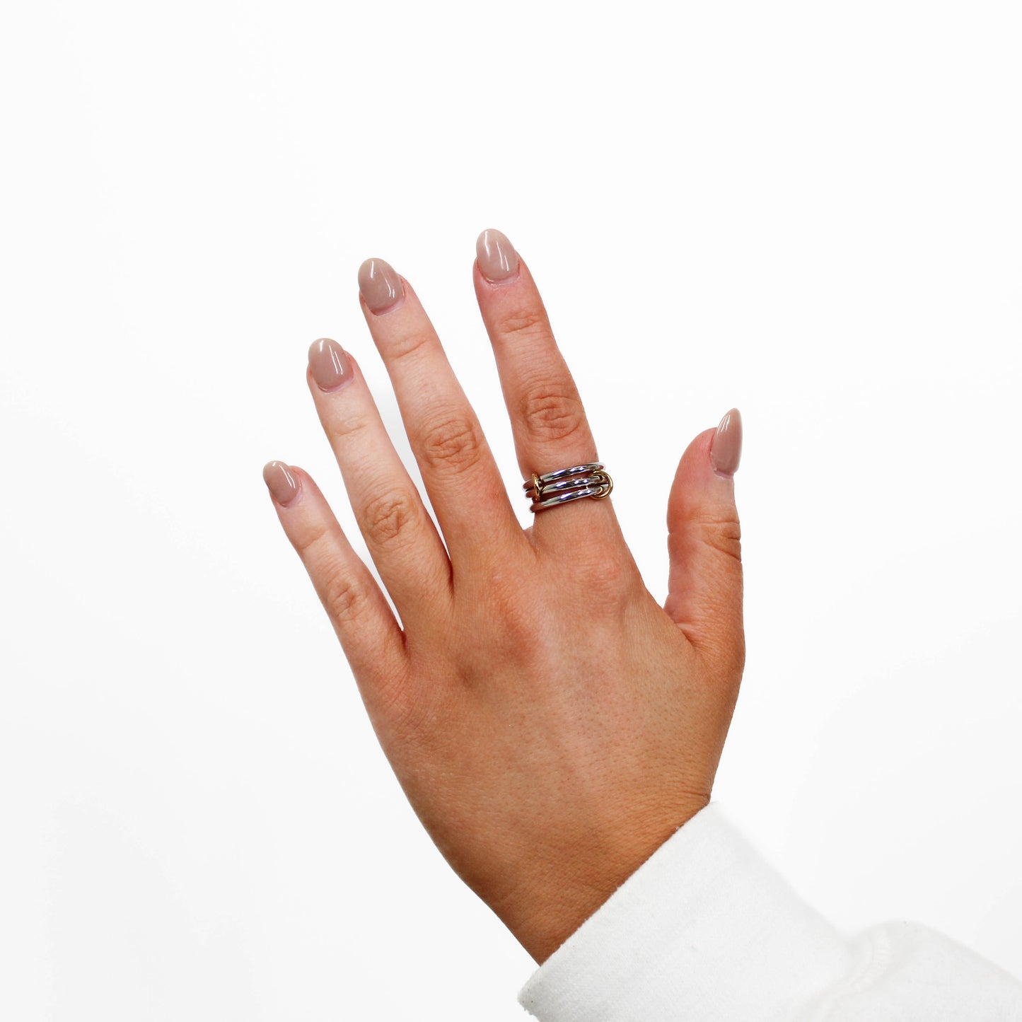 Hand wearing a silver interlocking link ring on a white background