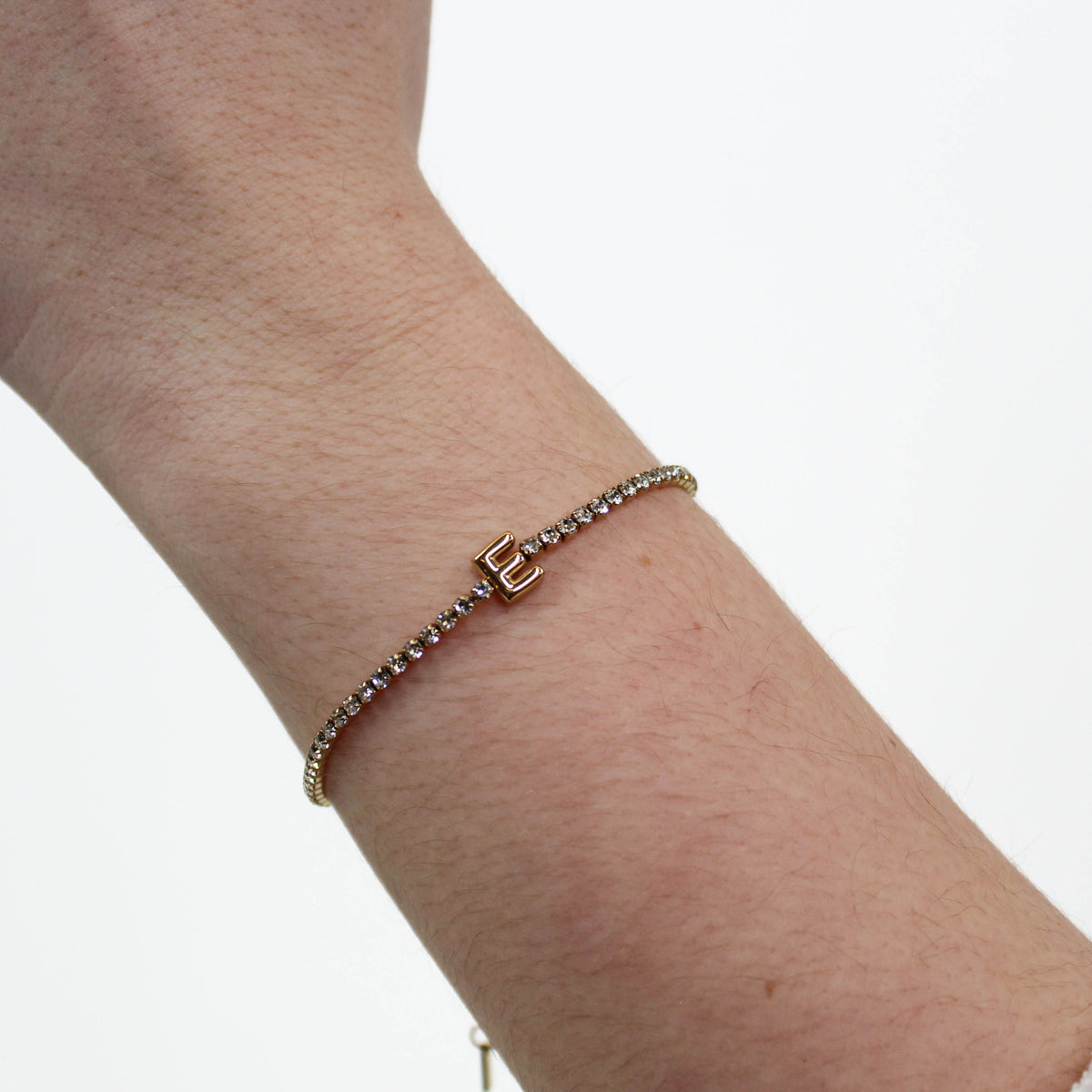 Rhinestone Letter Bracelet E on a wrist with a white background