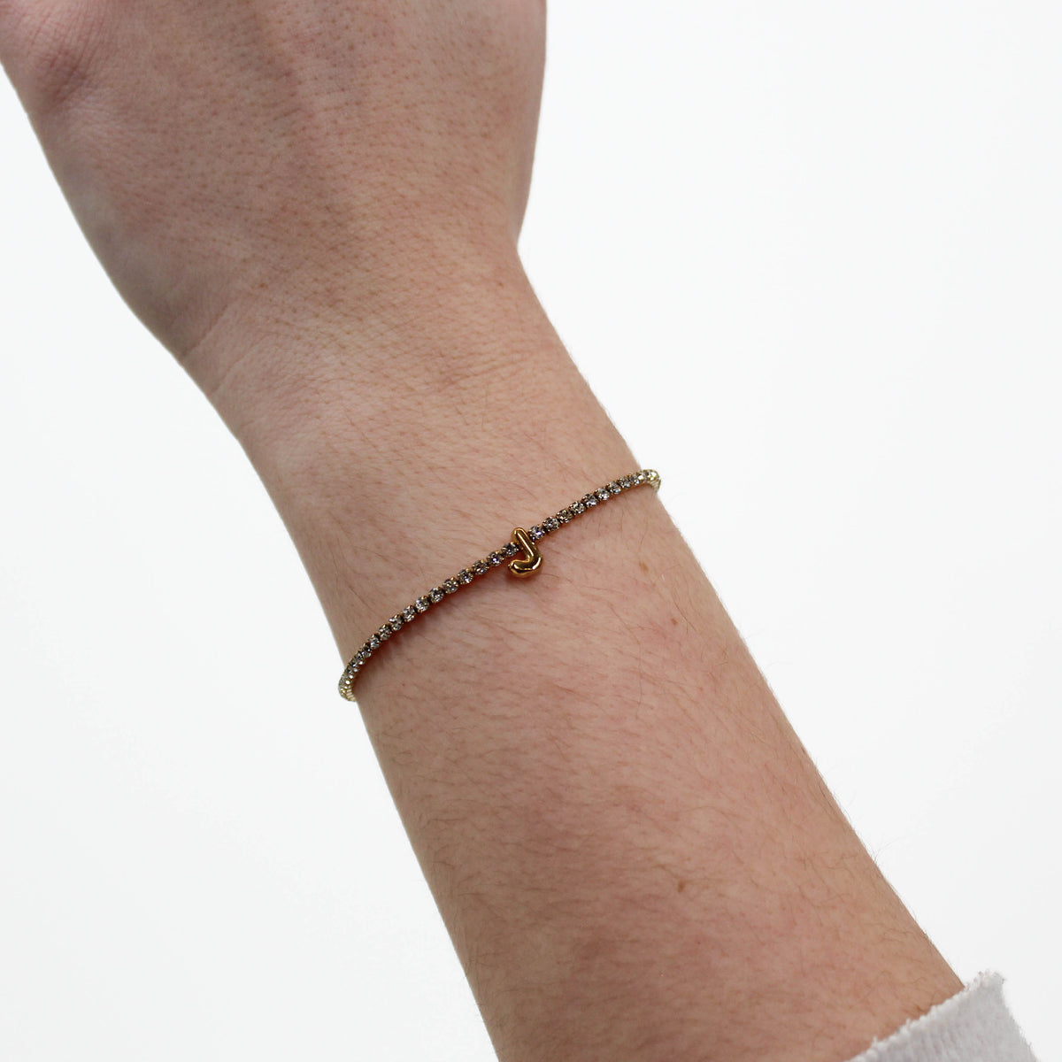 Rhinestone Letter Bracelet J on a wrist with a white background