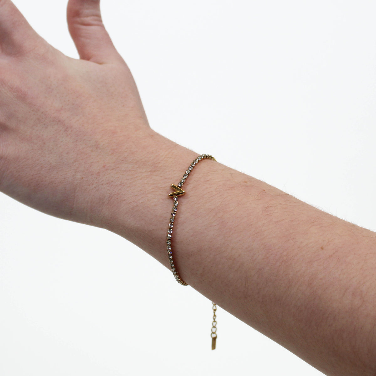 Rhinestone Letter Bracelet V on a wrist with a white background