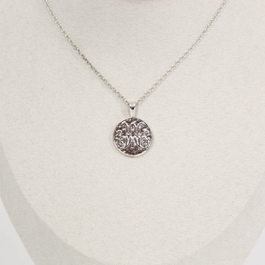Silver scripted M Disc necklace for Marist on a white mannequin bust