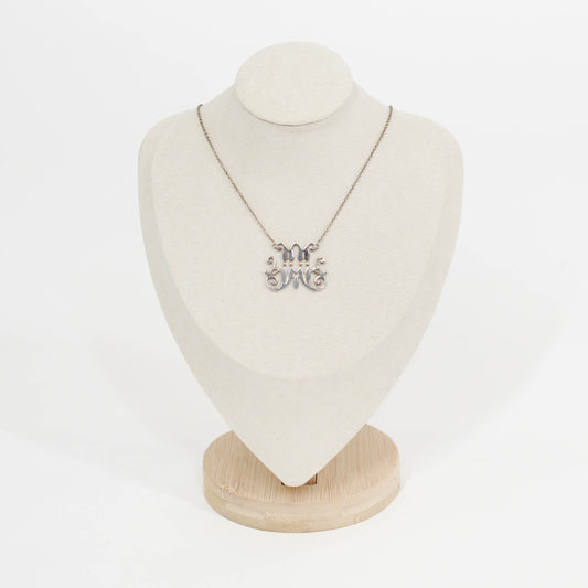 Necklace with a silver scripted M for Marist pendant on a mannequin bust against a white background