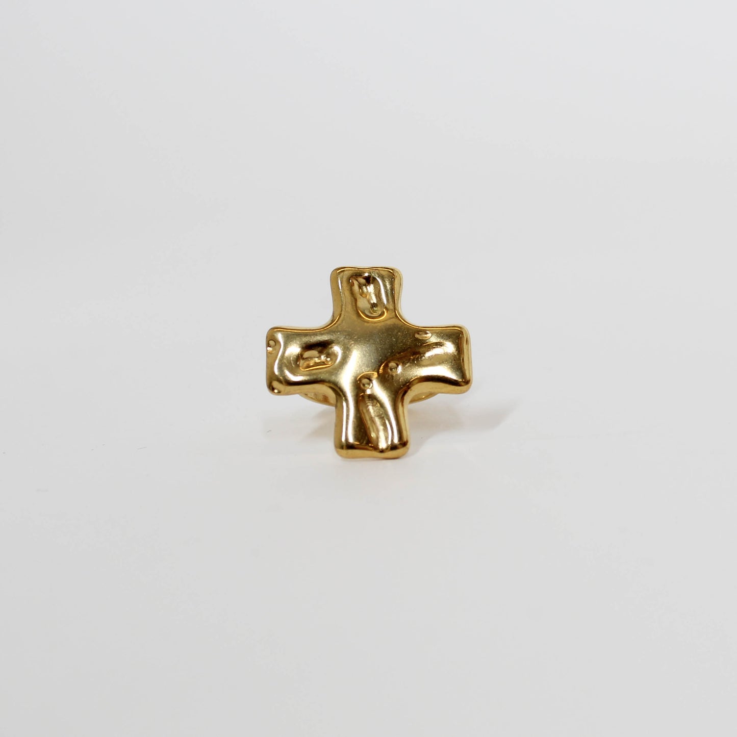 Gold cross ring on a white background