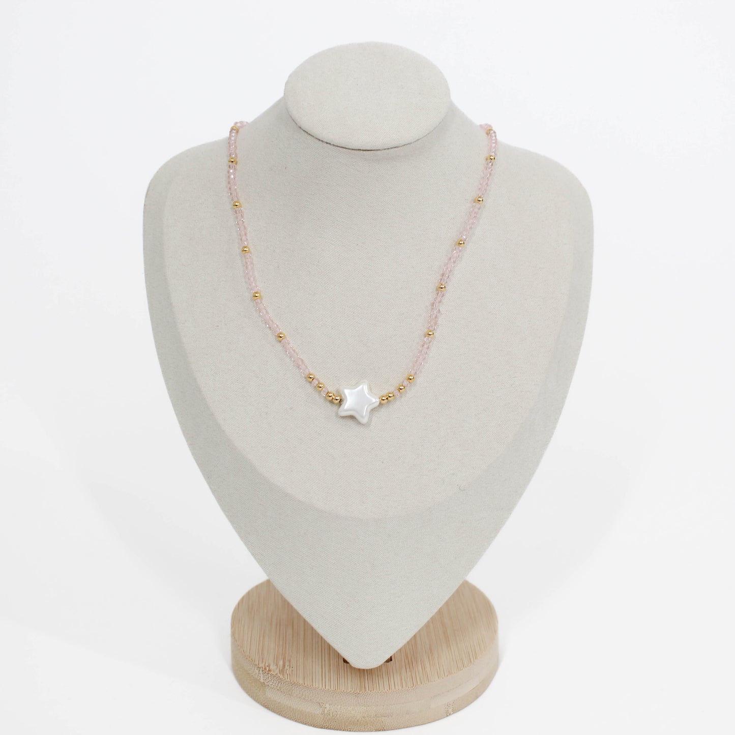 bubble star choker Necklace in pink with star-shaped pendant on a mannequin bust against a white background