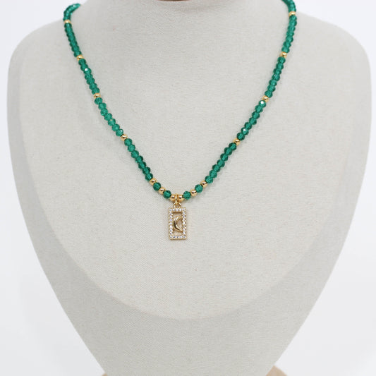 Green beaded moon pave choker necklace with a rectangular pendant on a mannequin bust.
