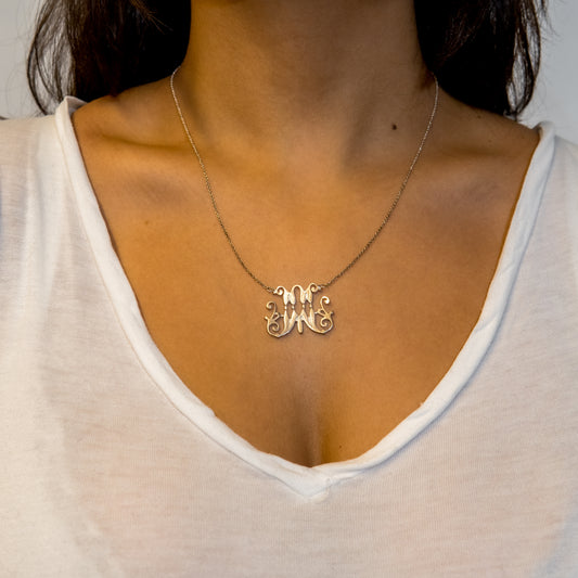 Model wearing a silver scripted M necklace for Marist