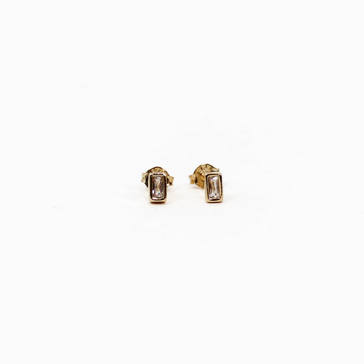 Gold baguette stud earrings with gemstones on a white background