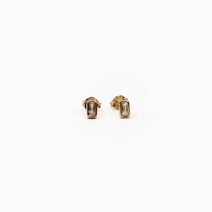Gold baguette stud earrings with gemstones on a white background