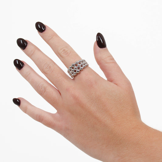 Hand wearing a silver beaded ball ring  on a white background