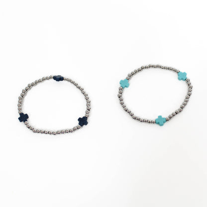 Two bracelets with silver beads and a blue and black cross accents on a white background.