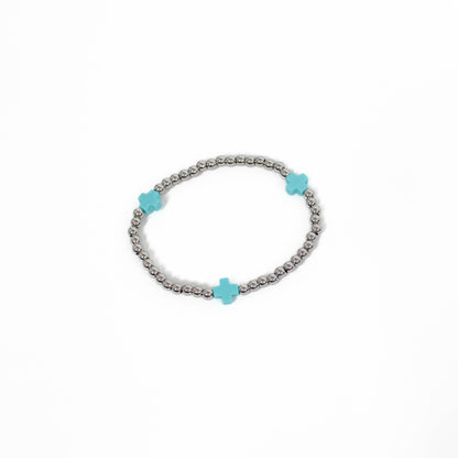 Bracelet with turquoise cross-shaped beads on a white background