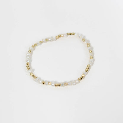Pearl and gold beaded bracelet on a white background