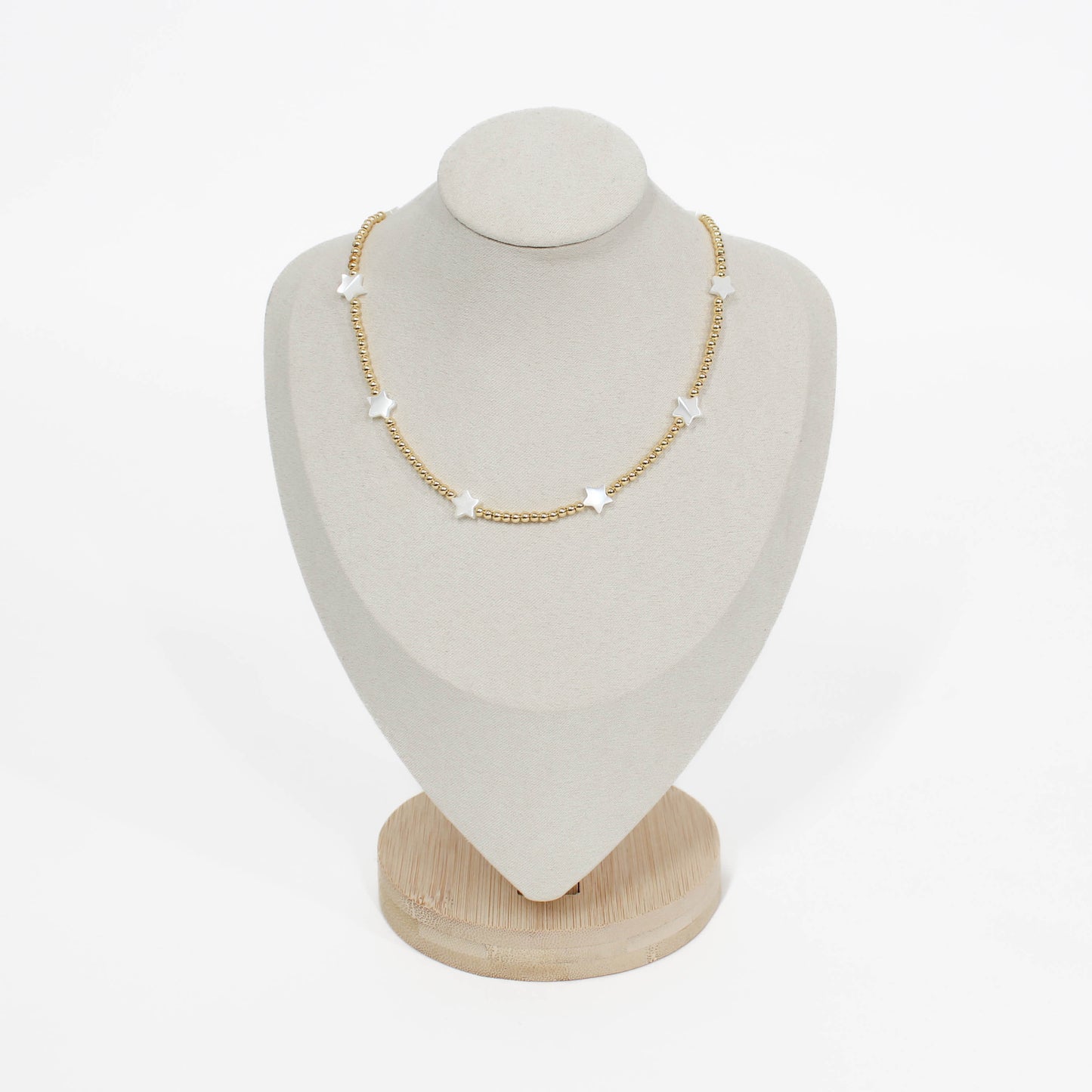 Beaded pearl icon star necklace on a white mannequin bust