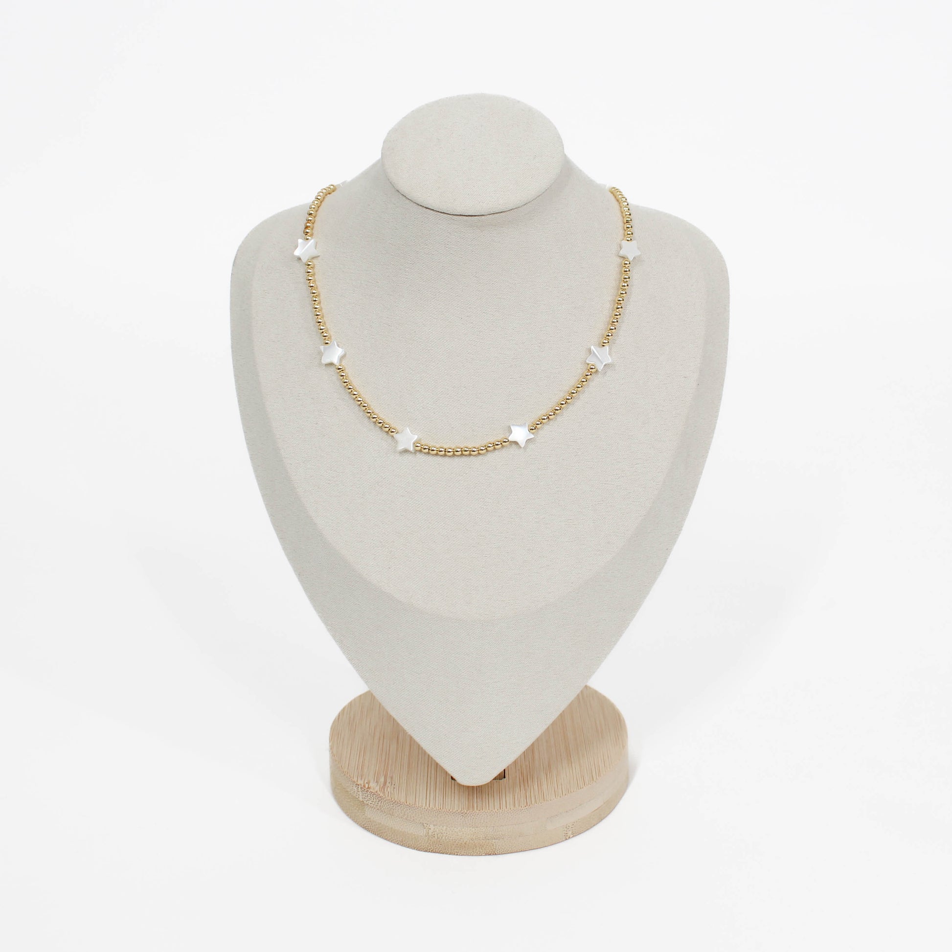 Beaded pearl icon star necklace on a white mannequin bust