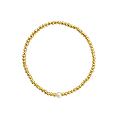 Gold beaded bracelet with a single white pearl on a white background