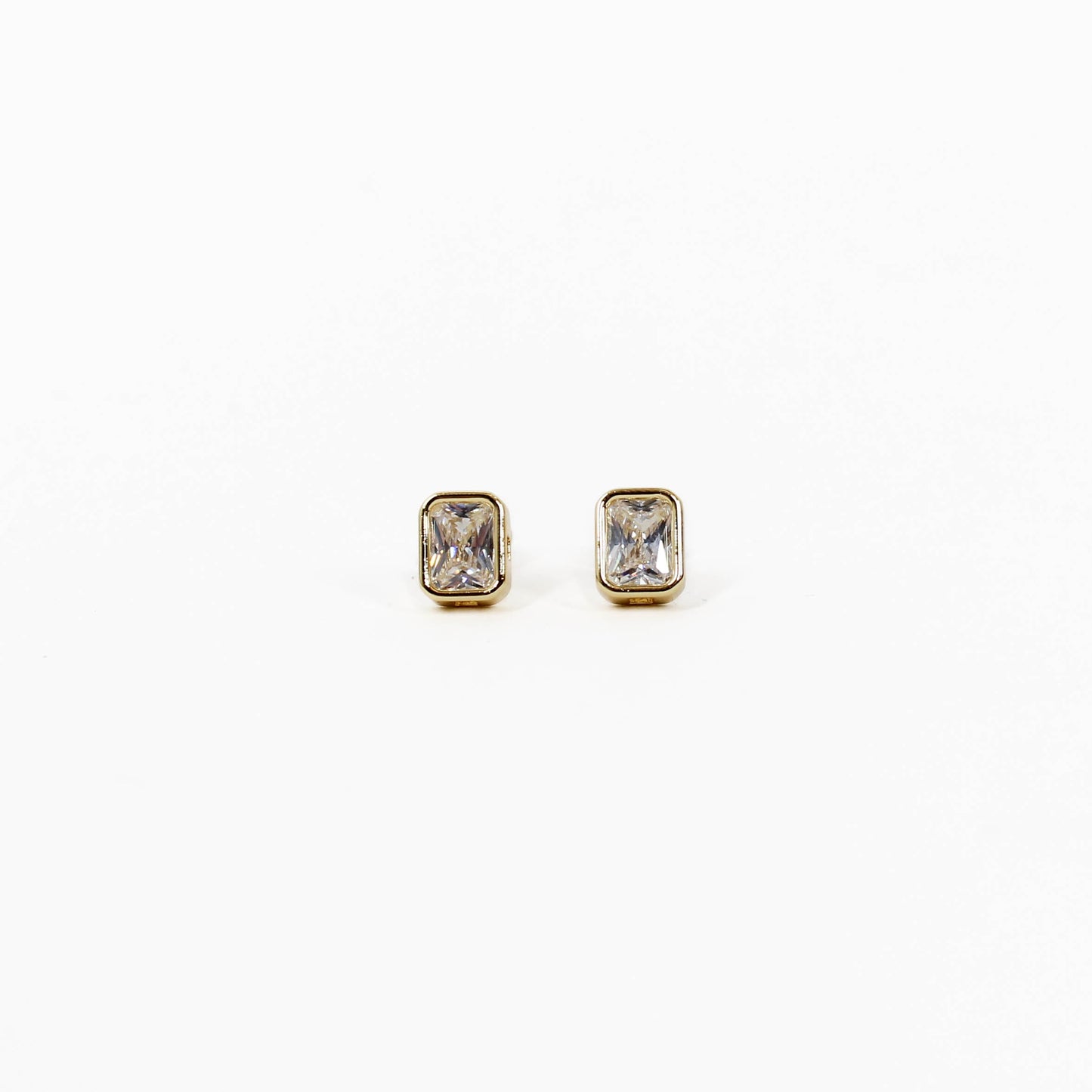 Pair of gold bezel stud earrings with gemstones on a white background