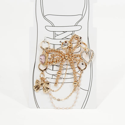 Set of gold shoe charms on a shoe with a white background