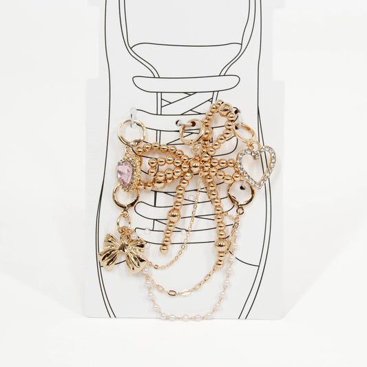 Set of gold shoe charms on a shoe with a white background