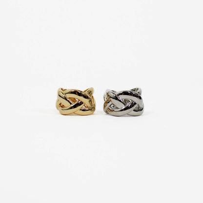 Two braided band knot-shaped ring, one gold and one silver, on a white background