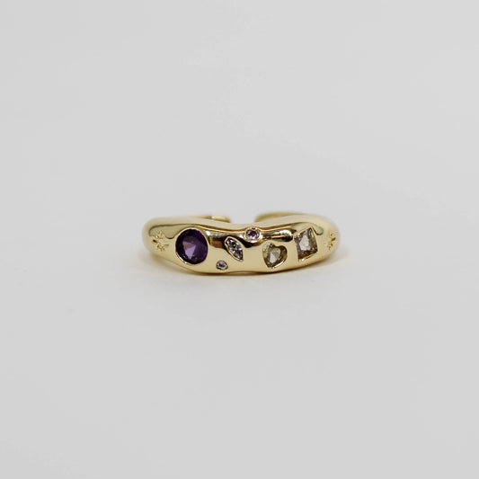 Gold ring with celestial lavender gemstones on a white background