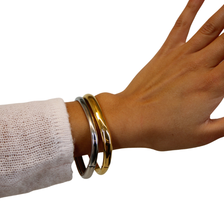 gold and silver bangle on hand model
