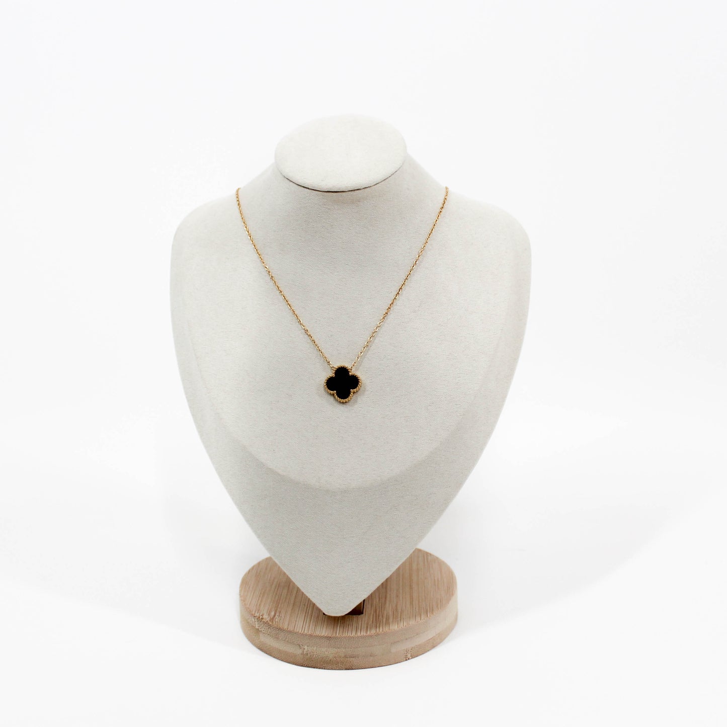 Clover Pendant Necklace with a black clover pendant on a white bust against a white background