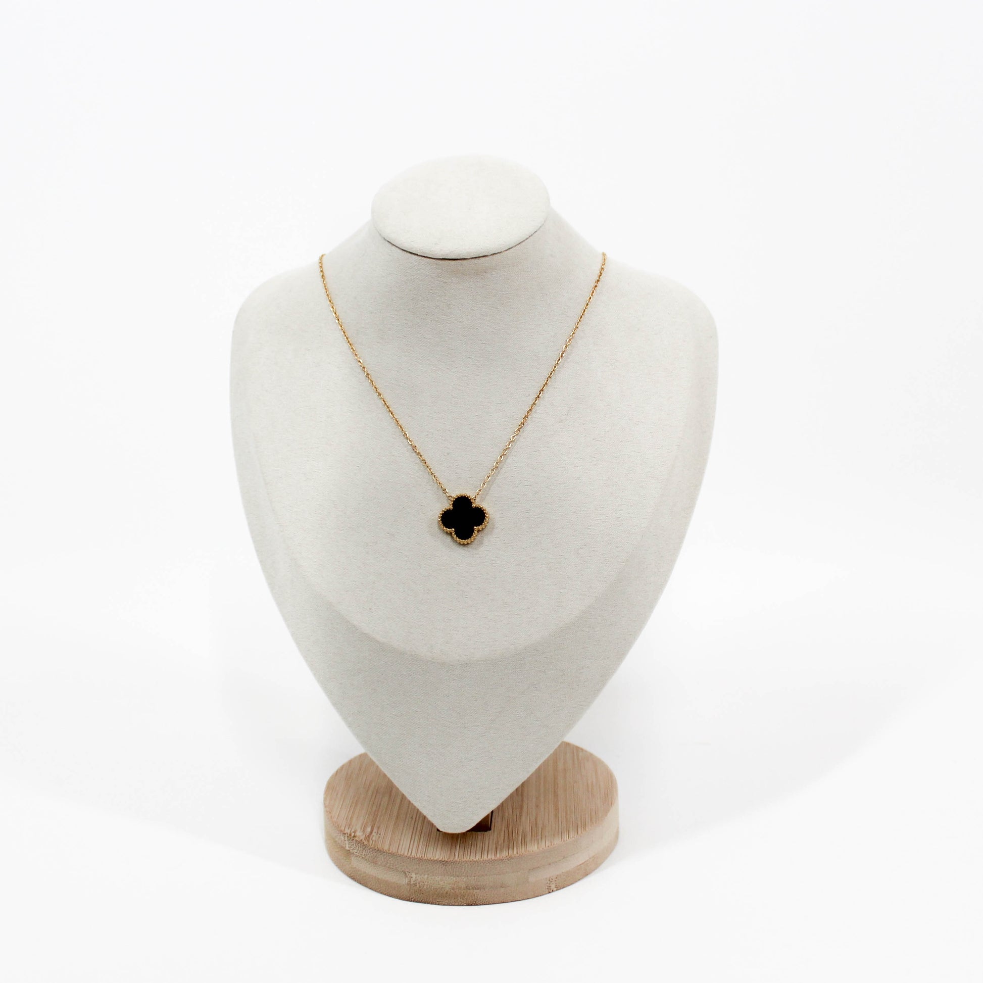 Clover Pendant Necklace with a black clover pendant on a white bust against a white background