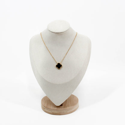 Clover Pendant Necklace with a black clover pendant on a white bust against a white background