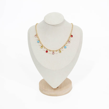 Necklace with colorful beads on a white bust with a wooden base
