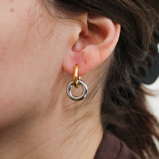 Close-up of an ear wearing a gold and silver mixed metal double hoop earring