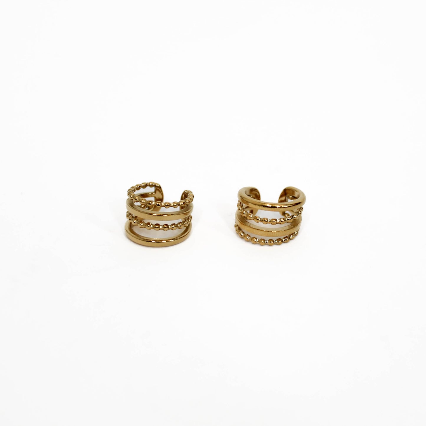 Pair of gold hoop ear cuff stack earrings on a white background