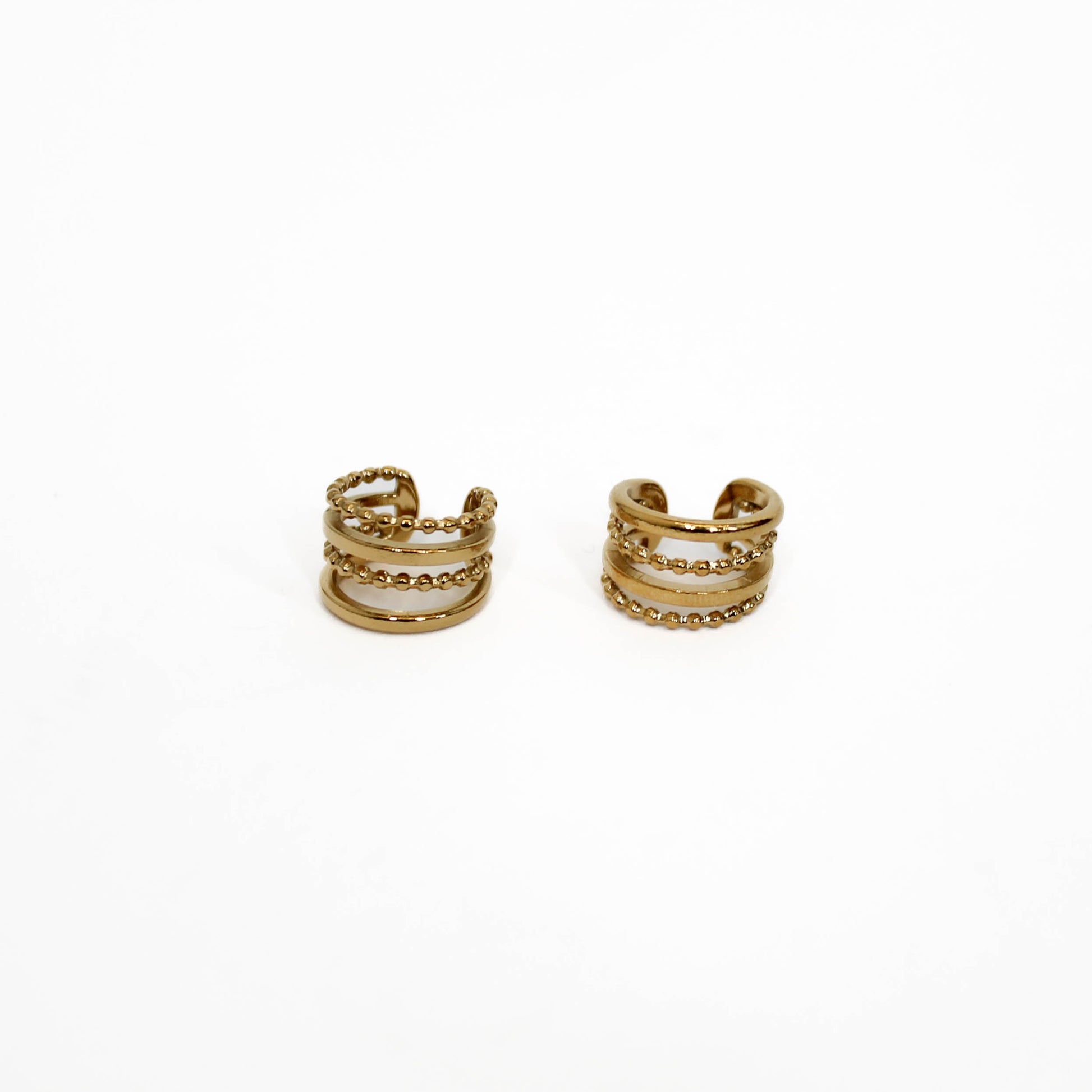 Pair of gold hoop ear cuff stack earrings on a white background