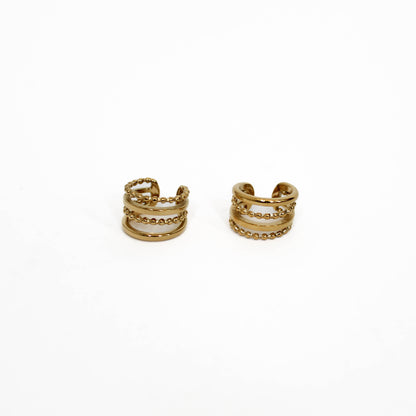 Pair of gold hoop ear cuff stack earrings on a white background