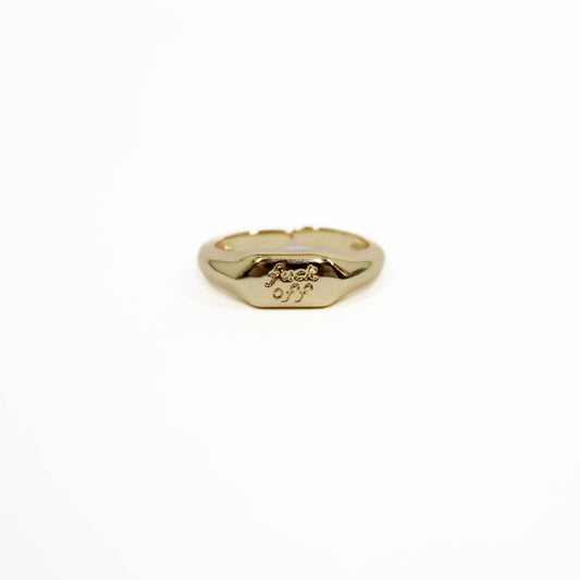 Gold ring with 'f**ck off' engraving on a white background